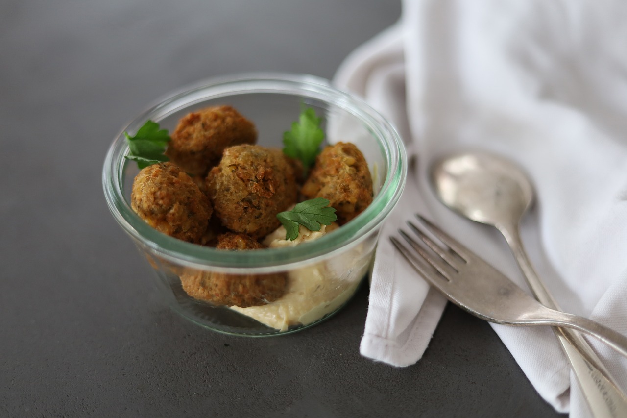Golden falafel over hummus in a glass bowl, topped with parsley